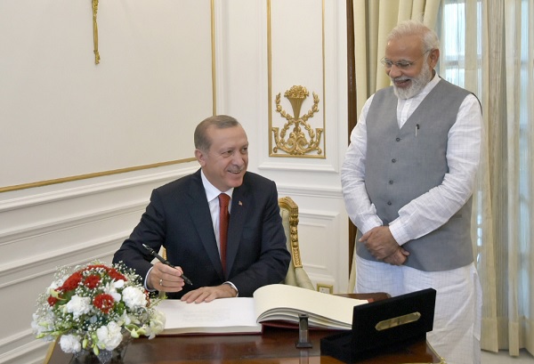 The-President-of-the-Republic-of-Turkey-Recep-Tayyip-Erdogan-signing-the-visitorsE28099-book-at-Hyderabad-House-in-New-Delhi.-The-Prime-Minister-Narendra-Modi-is-also-seen..jpg
