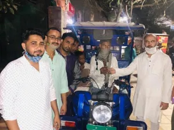 Shaikh Jilani (R) handing over key of e-rickshaw to horseman