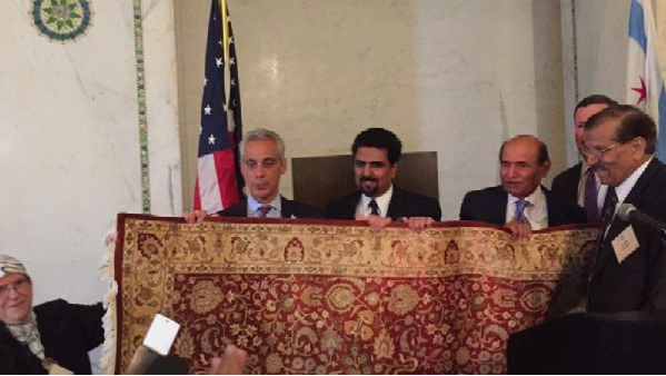 Chicago Mayor Rahm Emanuel accepts gift from host of Iftar dinner at the Chicago Cultural Center.